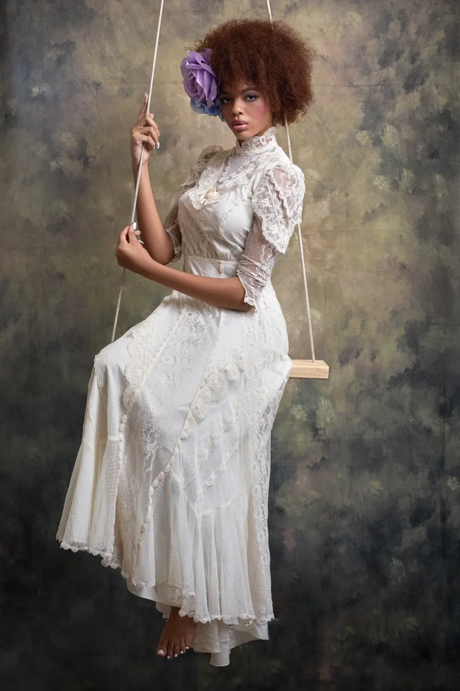 Vintage lace editorial on a studio swing with hand-painted backdrop
