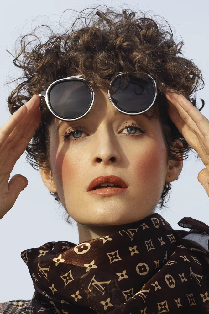 Editorial portrait with round sunglasses and printed silk scarf