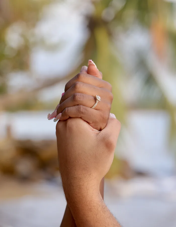 Detail of the engagement ring and clasped hands after the proposal